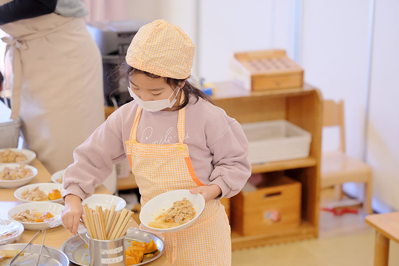 子どもが給食を盛り付ける